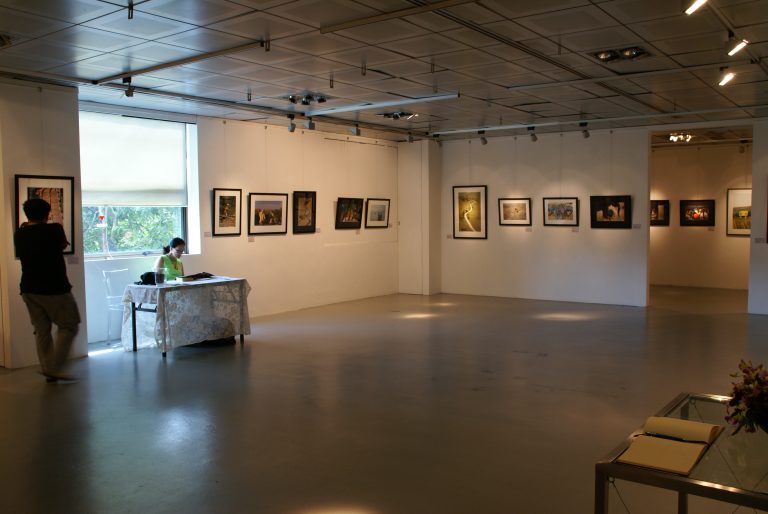 A wide view of framed photographs displayed in a gallery